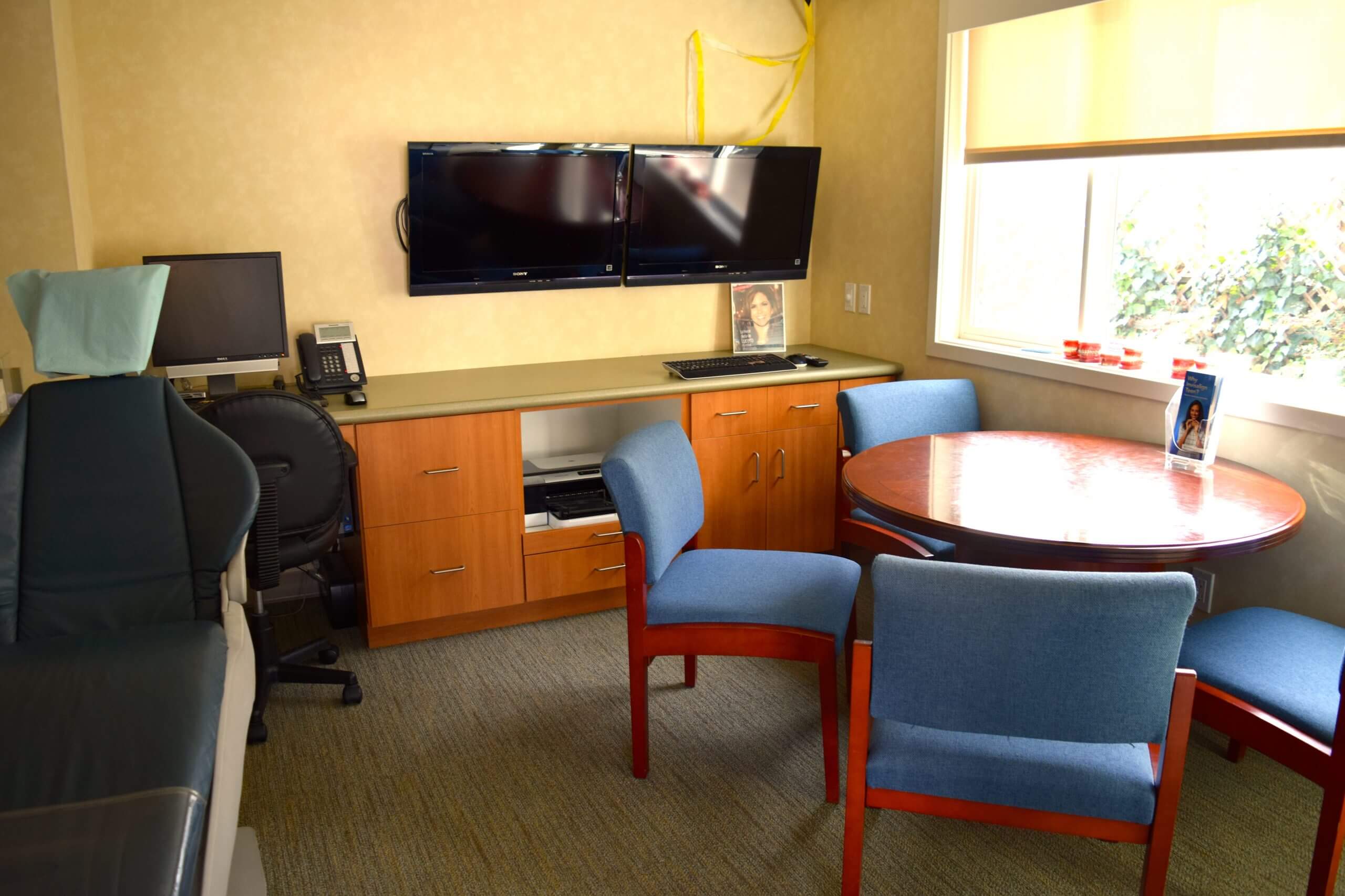 office area with round table and dental chair